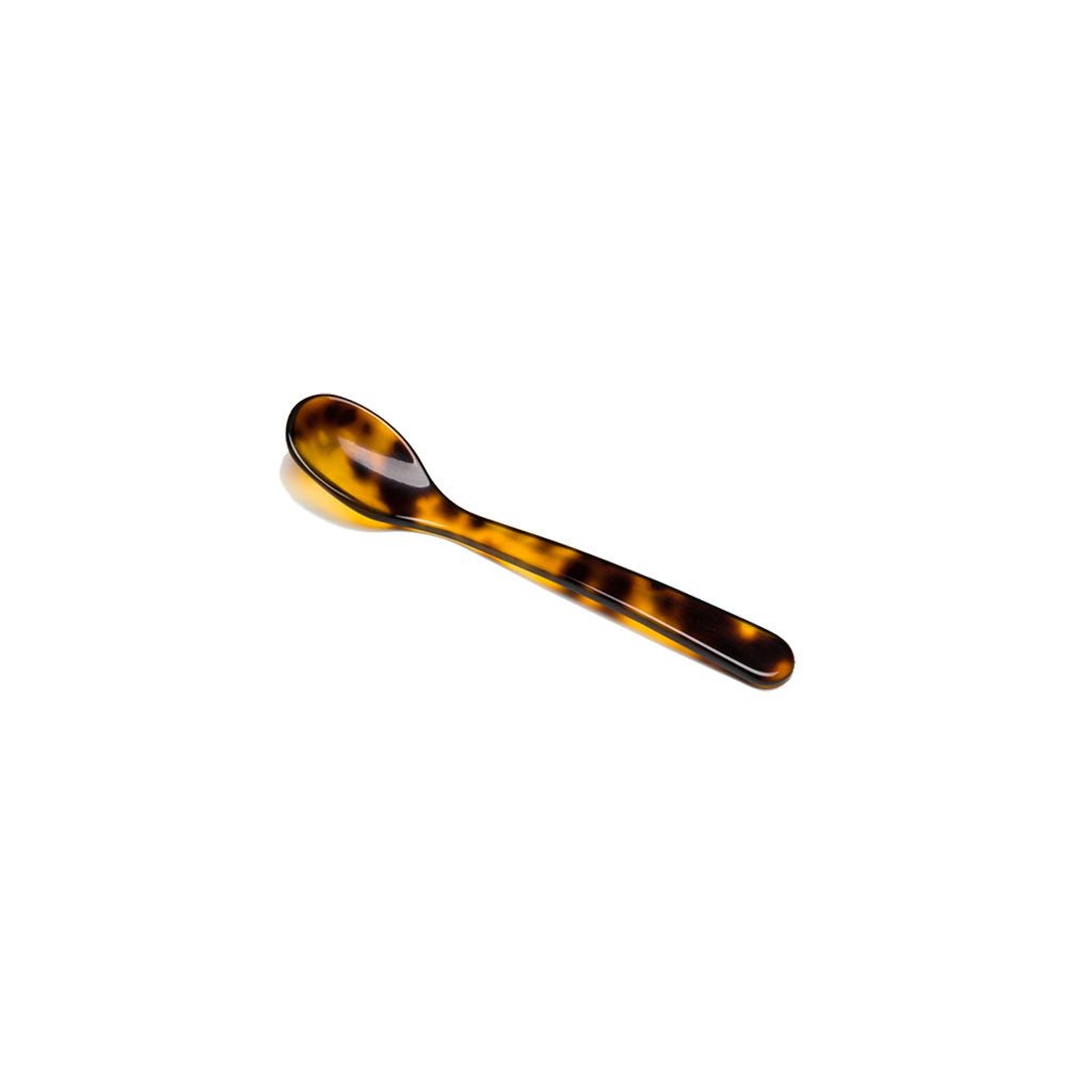 Tortoiseshell acrylic salt spoon on white background