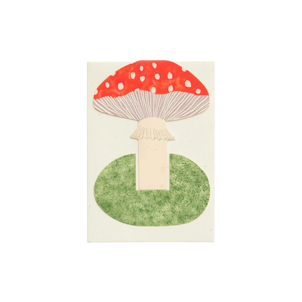 Red mushroom card on green grassy base with envelope on white background