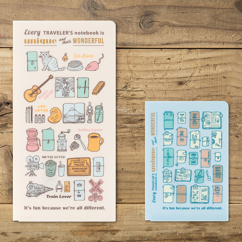 Two clear folders in regular and Passport sizes with colorful Traveler's Company illustrations on wooden background