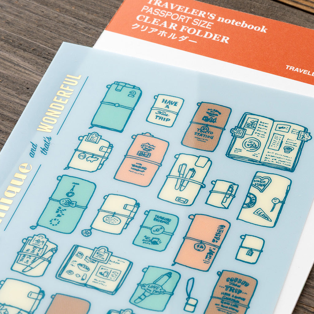 A blue clear folder for Passport size Traveler's Notebook with colorful Traveler's Company illustrations on wooden background