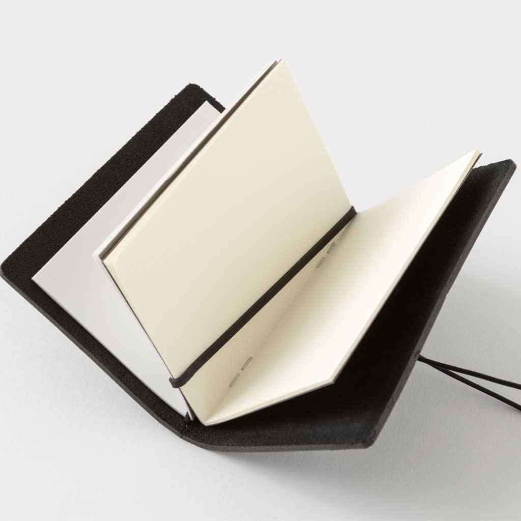 Black card-size notebook with open pages on a white background