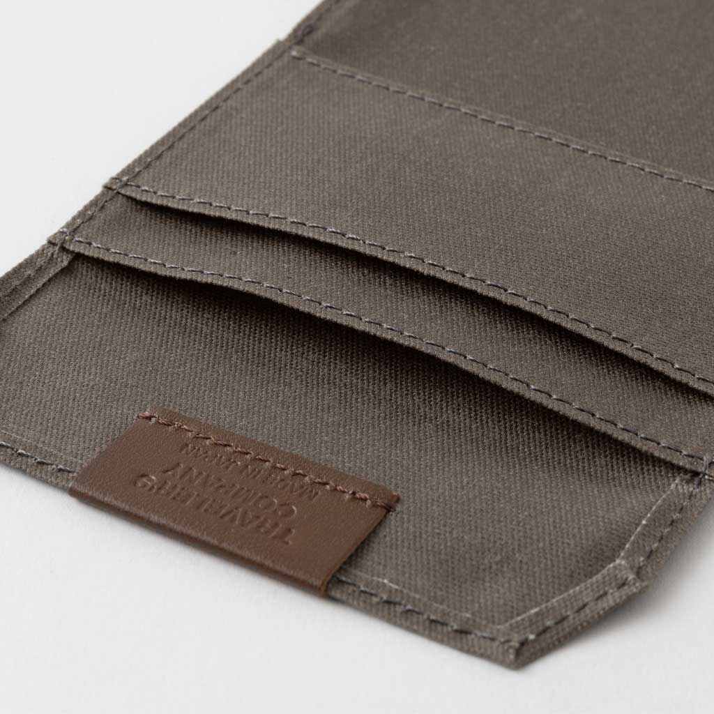 Open brown zippered case against light background