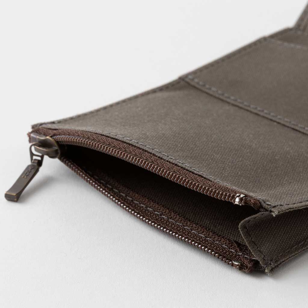 Open brown zippered case against light background