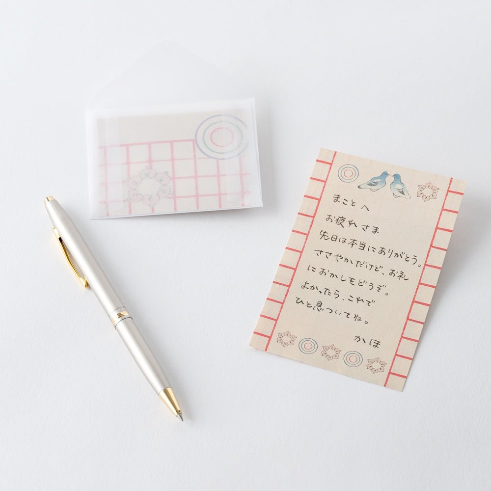 Japanese text written on Unsodo mini letter paper next to pen on white background