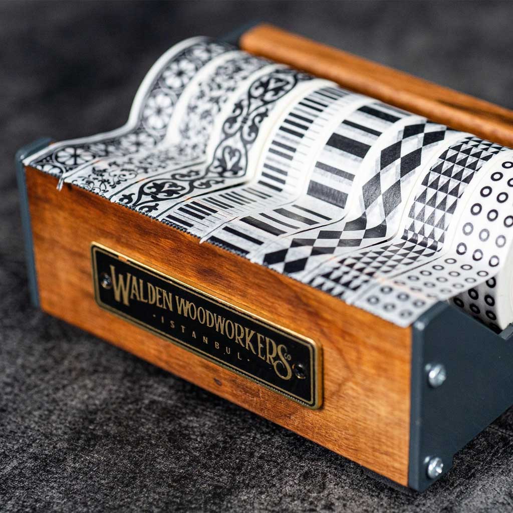 Medium wooden washi tape dispenser with patterned tapes on dark background