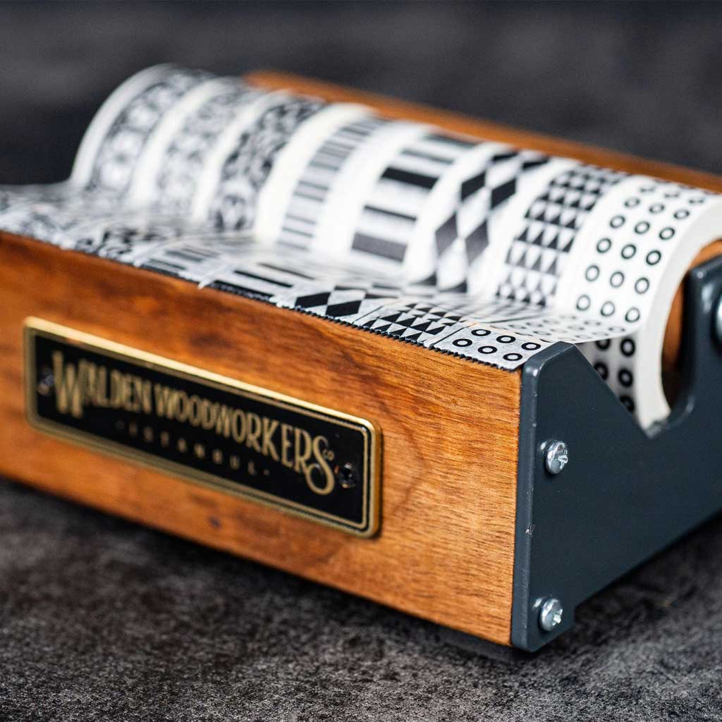 Medium wooden washi tape dispenser with patterned tapes on dark background