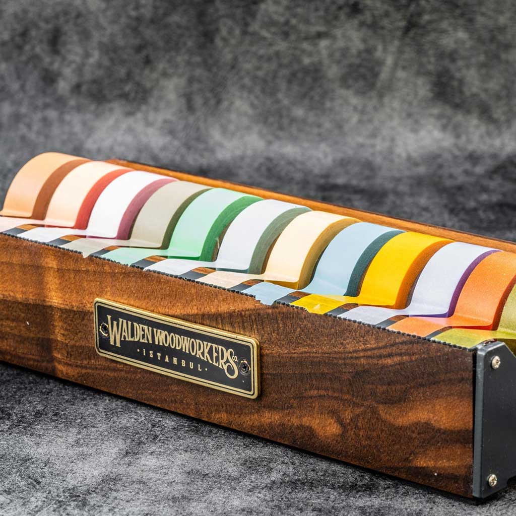 Large wooden washi tape dispenser with colorful tapes on dark background