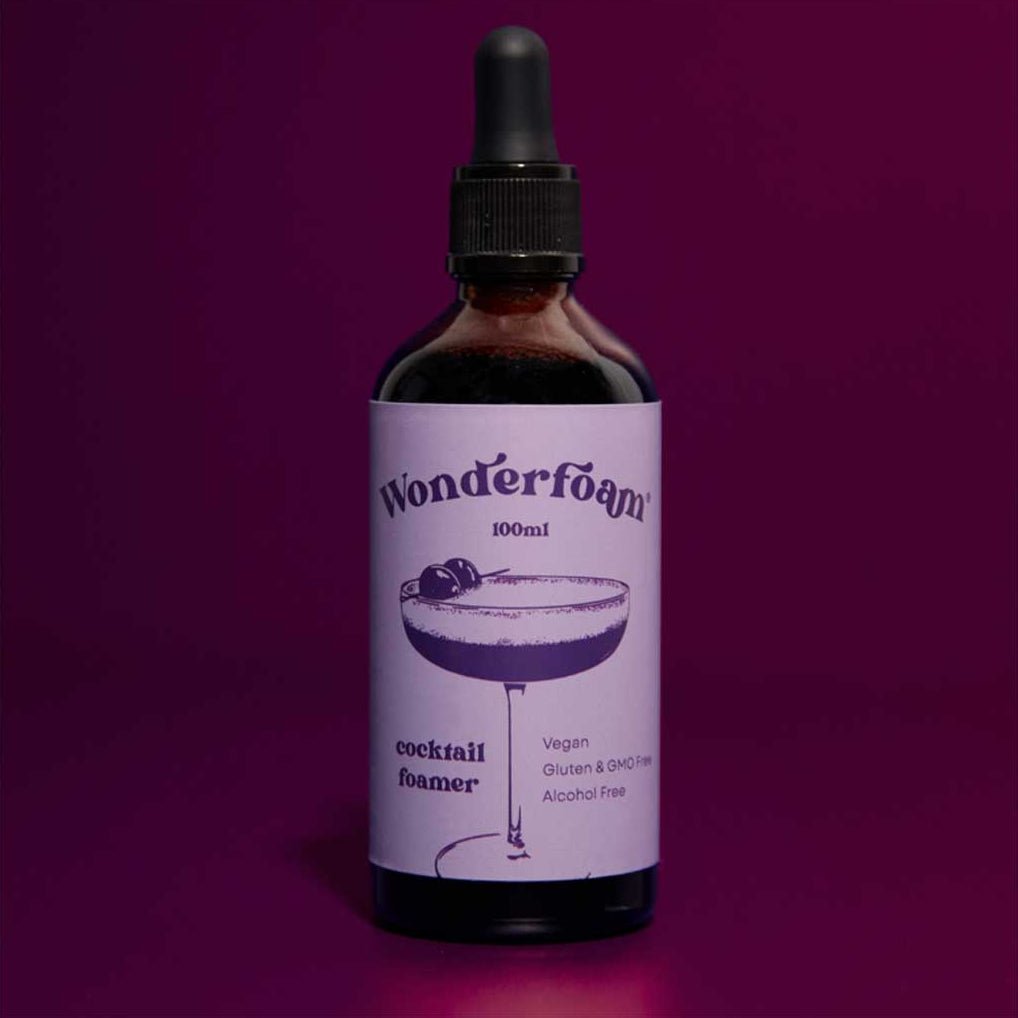 Bottle of wonderfoam cocktail foamer with purple label on purple background