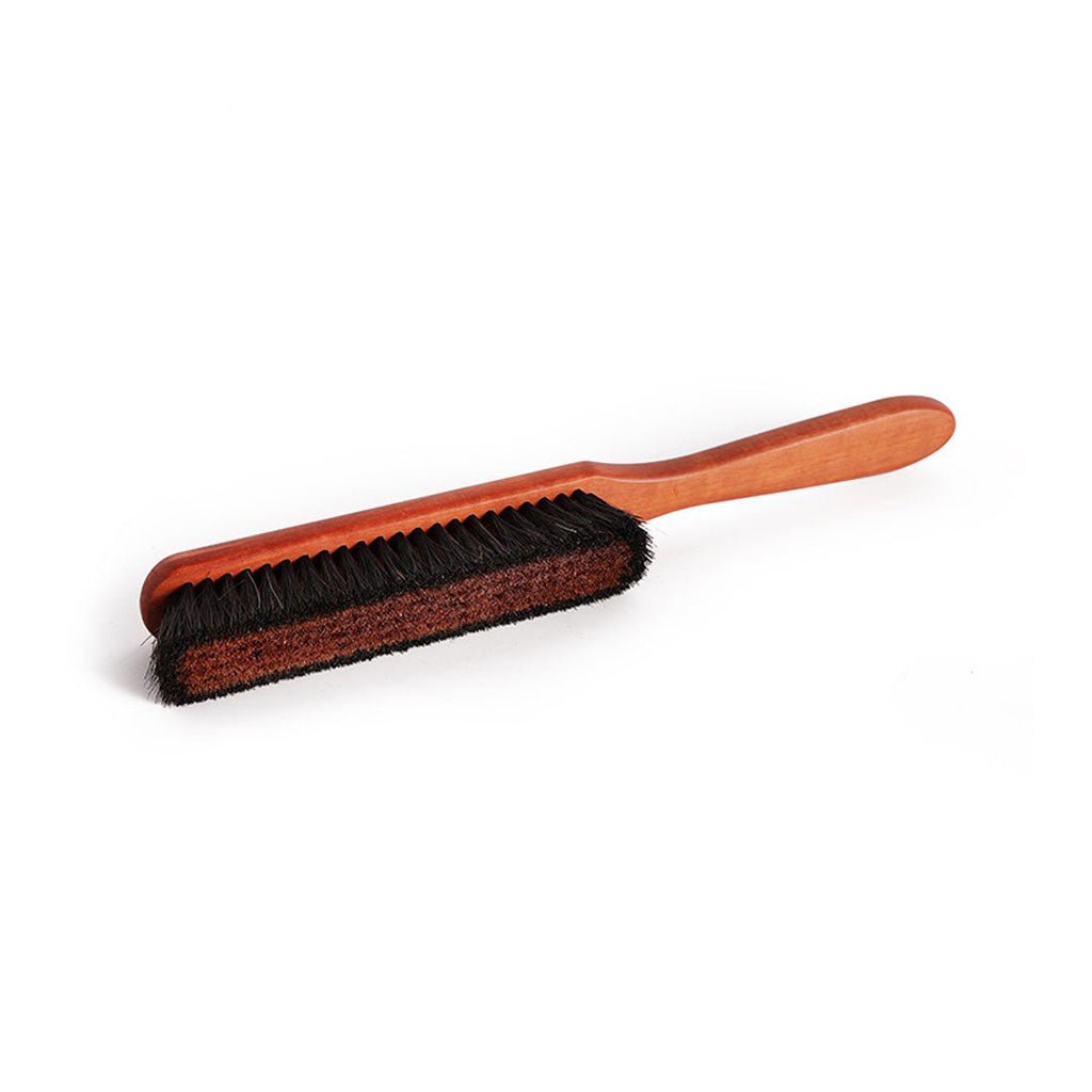 Wooden clothes brush with black and copper bristles on a white background