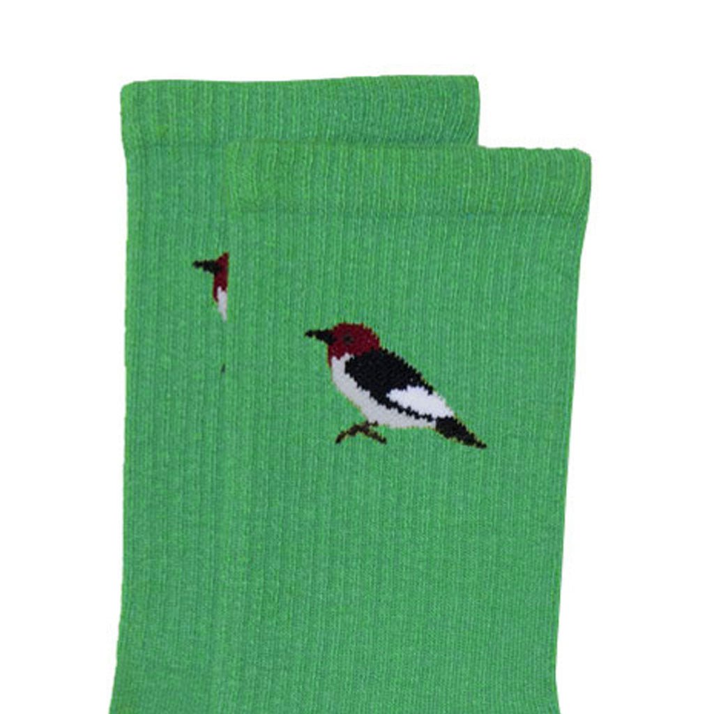 close-up of green crew sock with a small embroidered woodpecker detail near the ankle