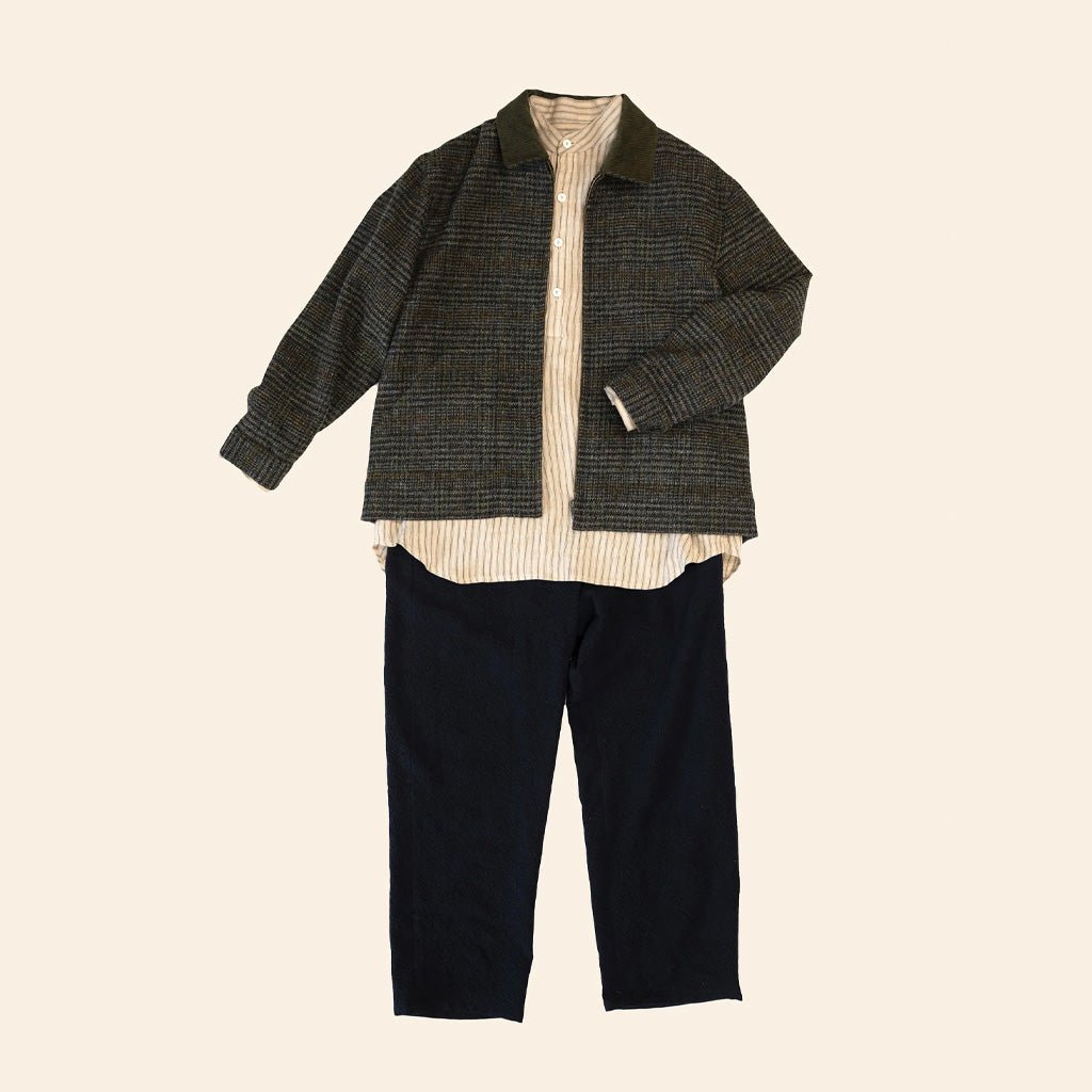 Three-piece outfit with a jacket, shirt, and pants on a beige background