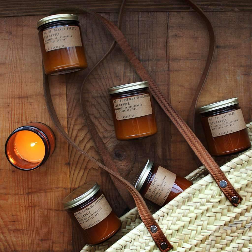 Amber glass jar candles laying on wooden surface