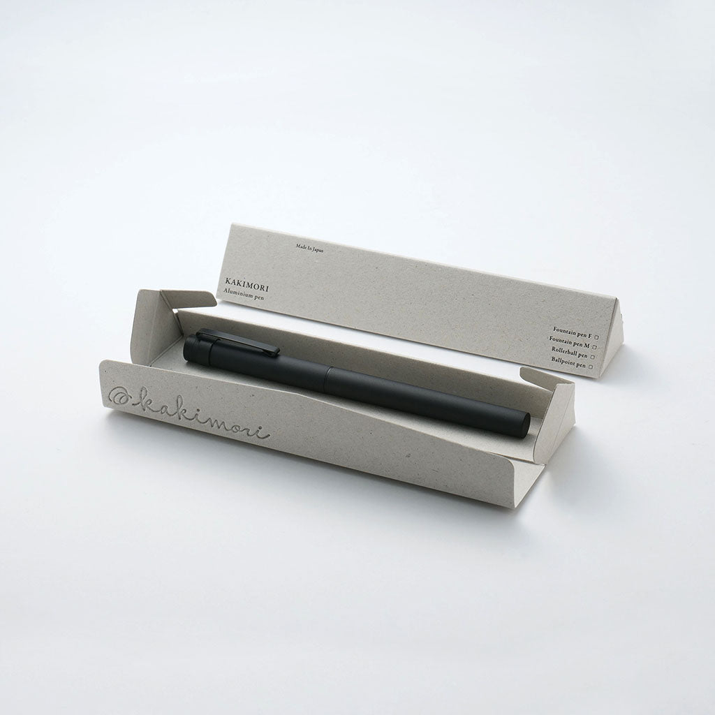 Black pen in an open beige box on a white background