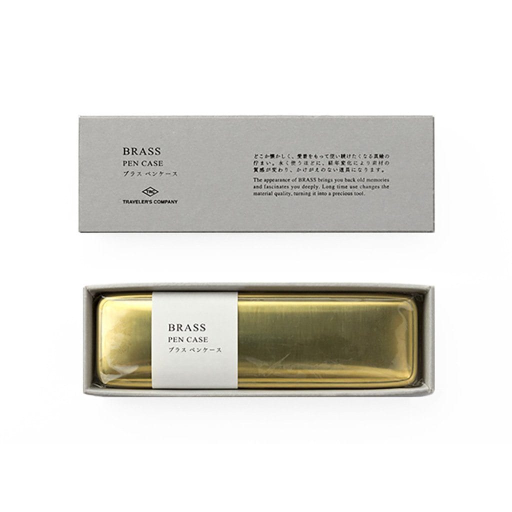 Brass pen case in a box with a label on a white background
