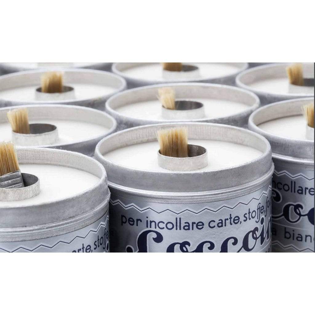 Multiple tins of Coccoina adhesive paste open with brushes