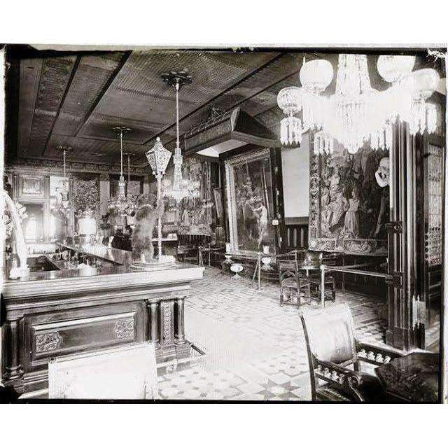 Vintage interior of a grand room with ornate furniture and chandeliers.