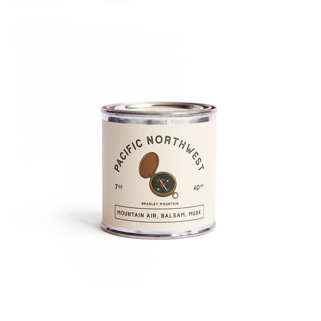 Candle tin of Pacific Northwest with notes of mountain air, balsam, musk on a white background