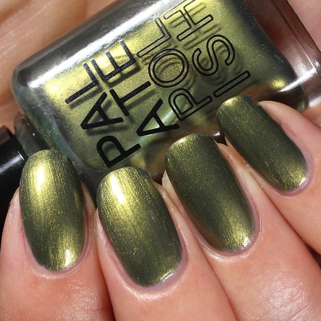 Hand wearing iridescent green Pickle nail polish holding bottle