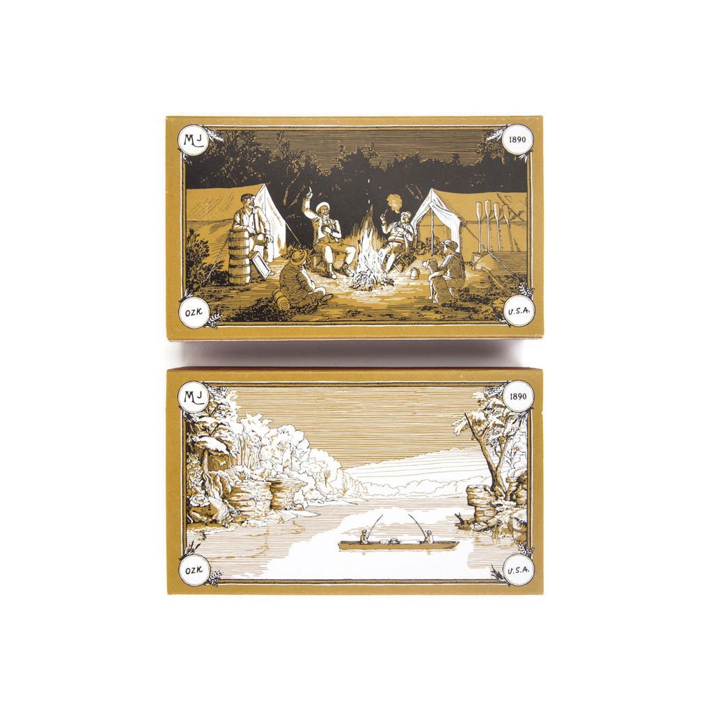 Two boxes of matches depicting scenes of people around a campfire and a landscape with a fishing boat.