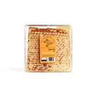 Block of New England honeycomb in clear container with yellow Aquidneck Honey label on white background