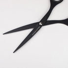 Black stainless steel scissors with 'TOOLS to LIVEBY' branding on blades on a light background.