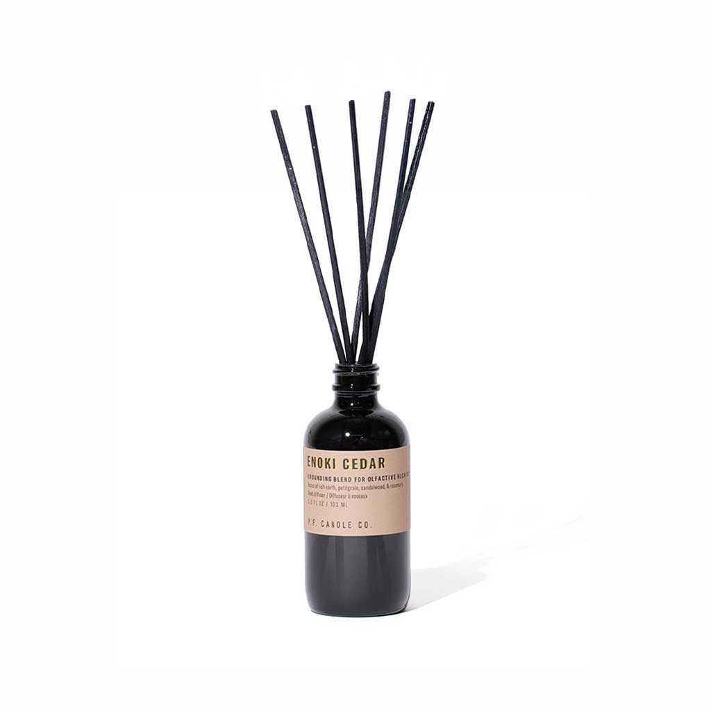 Enoki cedar reed diffuser bottle with black reeds on white background