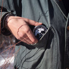 person putting a tin of all salve into pocket