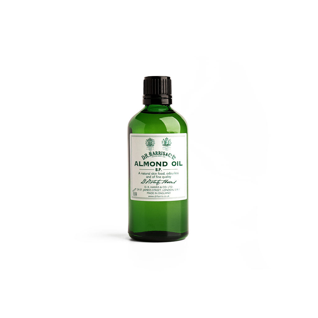 Green bottle of almond oil by D. R. Harris on white background