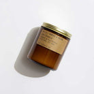 Scented candle with a gold lid and brown label on a white background