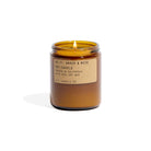 Amber glass candle with a label on a white background