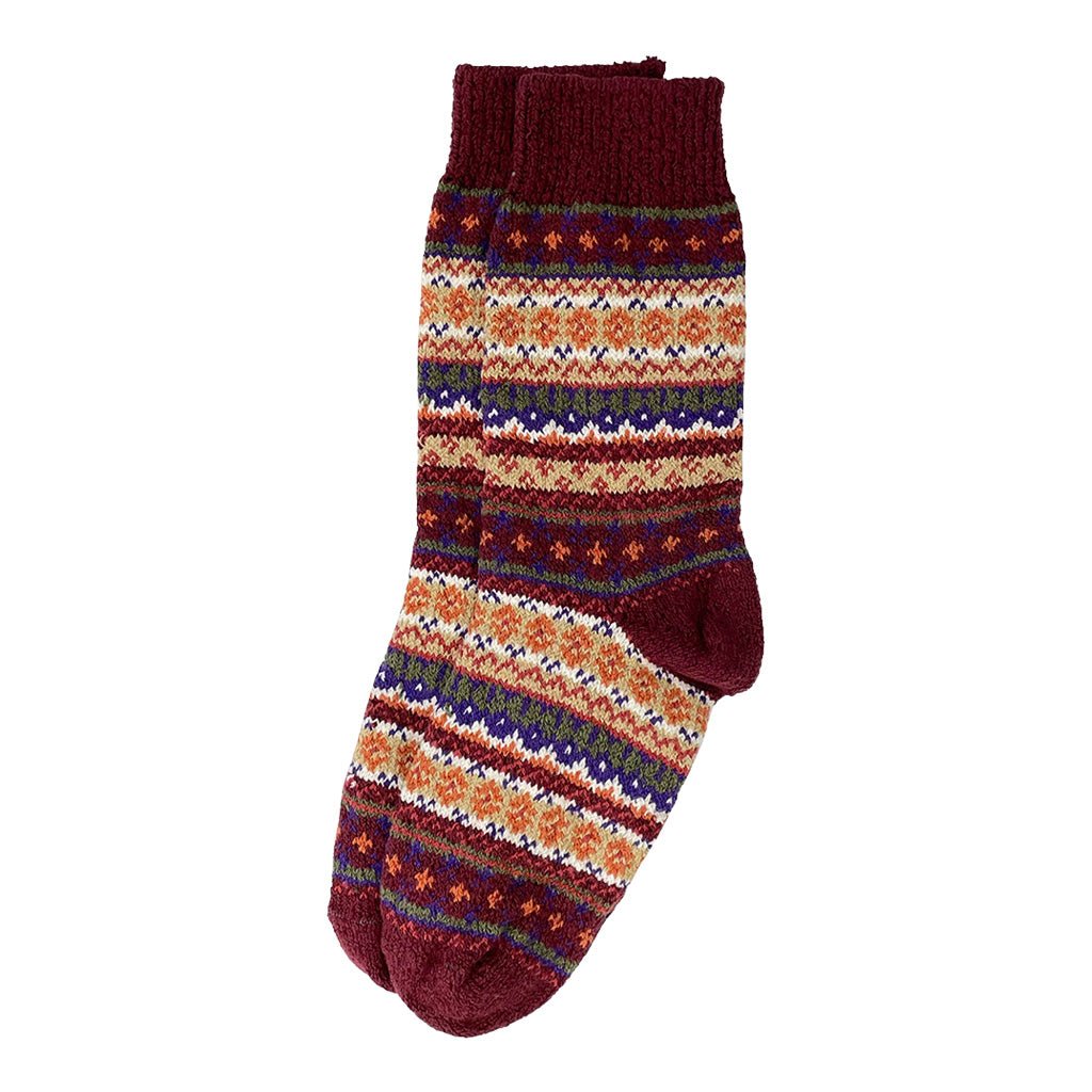 A colorful cotton sock in a fair isle pattern in shades of burgundy, cream, and orange.