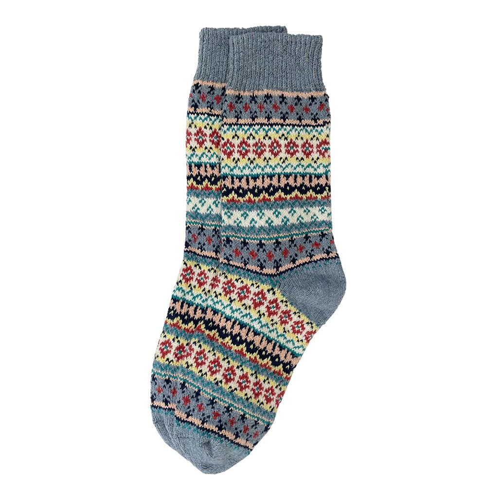 A colorful cotton sock in a fair isle pattern in shades of denim blue, cream, black, and red.