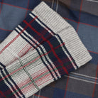 Plaid sock on top of plaid bedding.