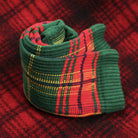 Rolled up sock with red and green plaid pattern on plaid fabric.