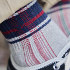 Model wearing plaid sock and black shoes.