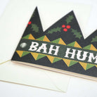 Close up of die-cut holiday greeting card crown with text bah humbug