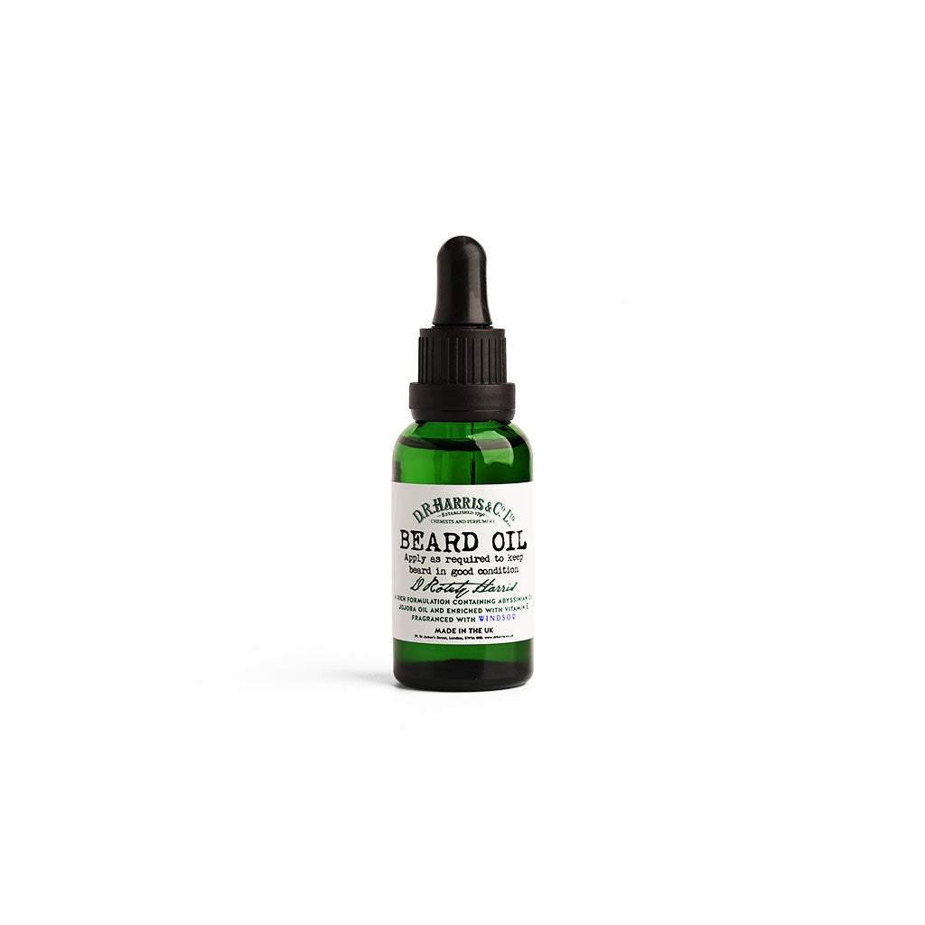 Green bottle of D. R. Harris beard oil on white background