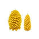 Two yellow beeswax candles shaped like pine cones, one larger and one smaller, shown on a plain white background.