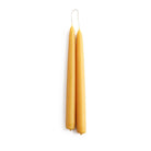 A set of two standard yellow beeswax taper candles on white background