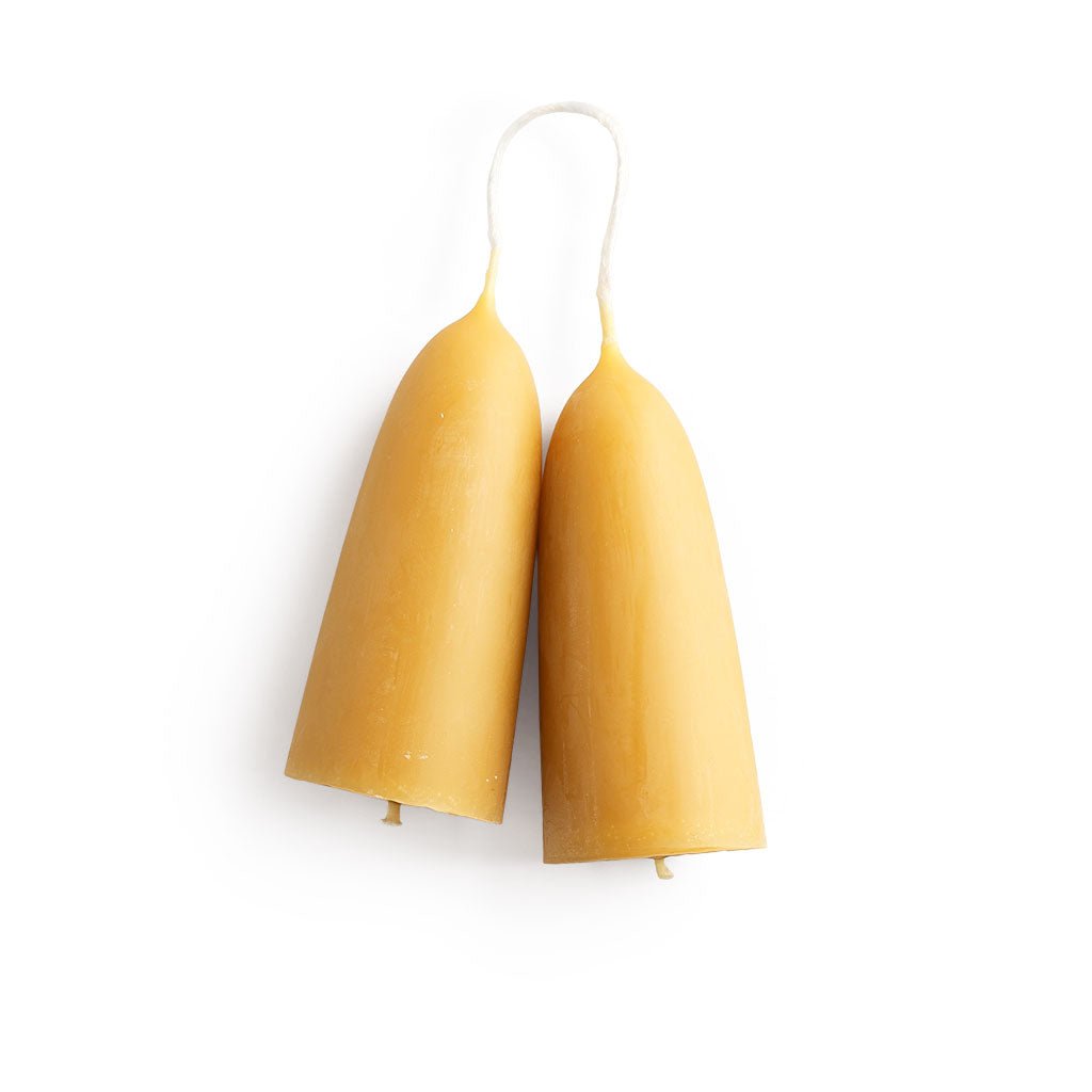 A set of two short, thick beeswax candles on white background