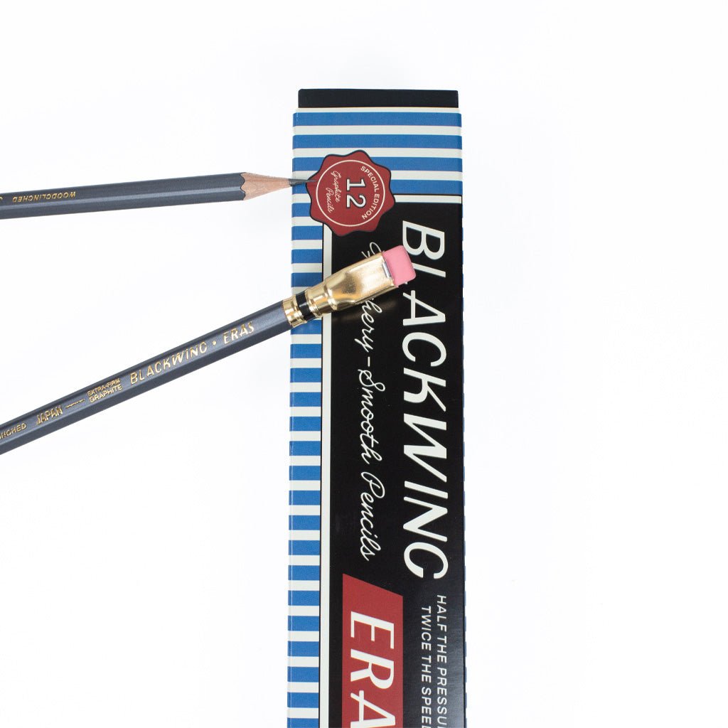 Blackwing pencil box behind two gray pencils.