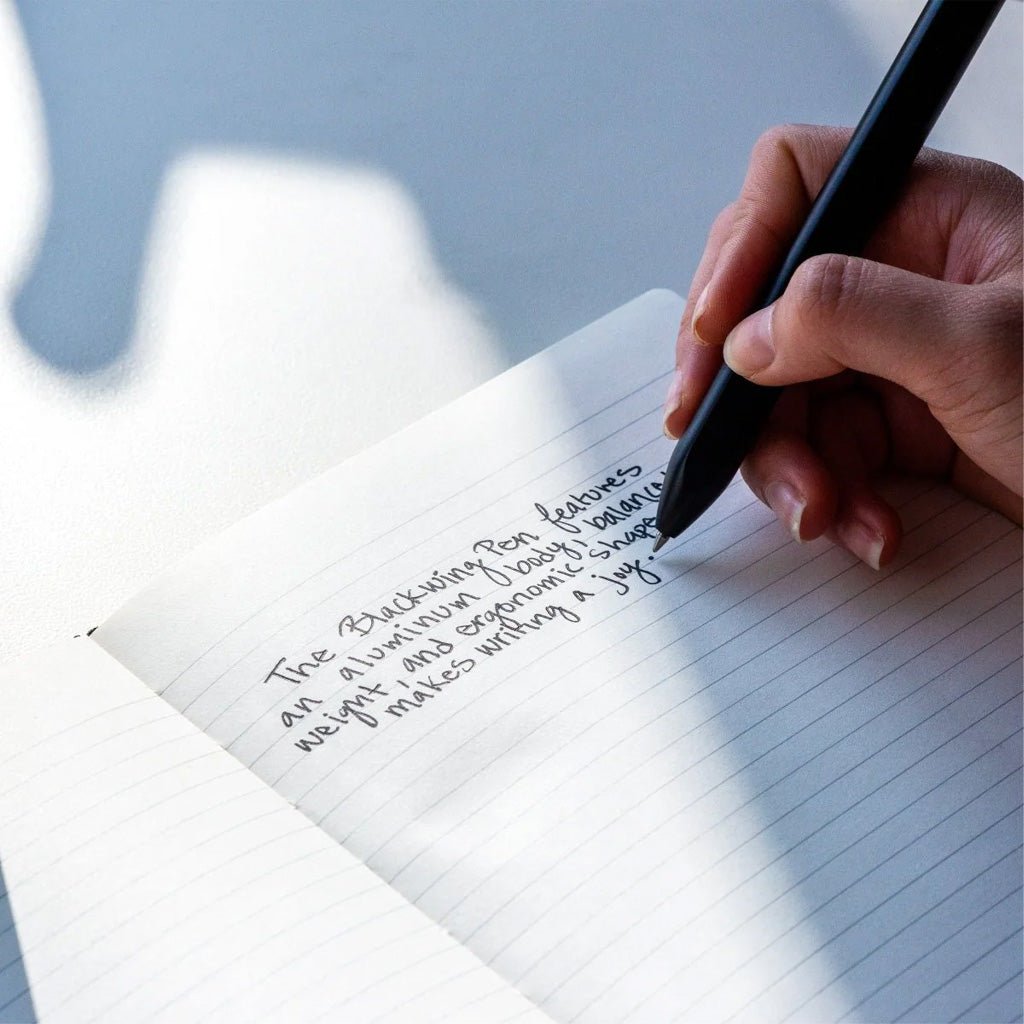 Hand writing on a lined notebook with Blackwing pen