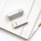 White stationery items including a pen, eraser, and notebook on a white background