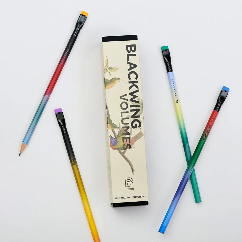 Box of Blackwing volume 458 pencils with bird designs next to gradient pencils on light background