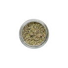 Small glass jar filled with dried herbs on a white background