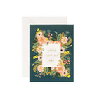 A Mother's Day greeting card with a floral design on a dark green background, featuring a white panel with the text 'Happy Mother's Day' in gold. Accompanied by a white envelope.