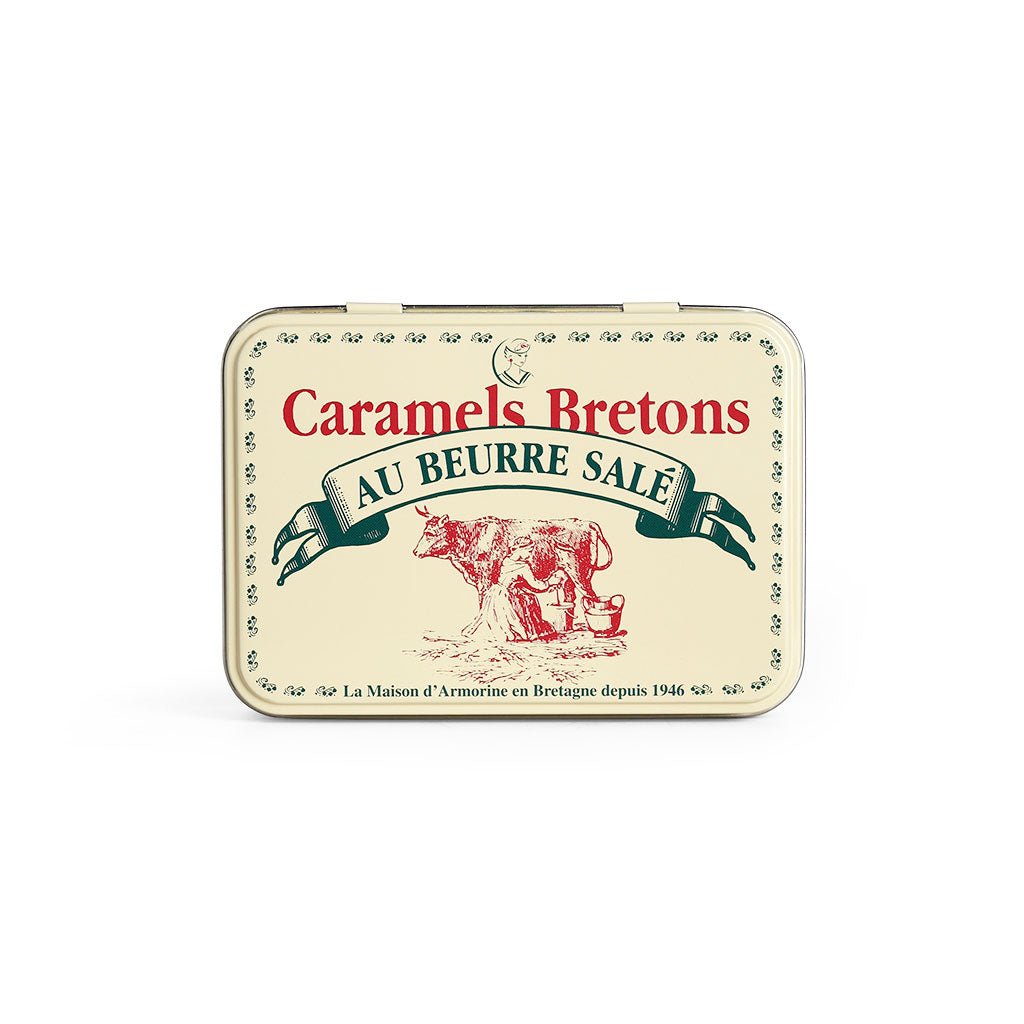 A cream colored tin with an illustration of a cow on the front and lettering in French.