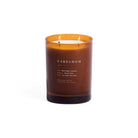 An amber glass jar candle with two lit wicks and white wax, labeled 'CARDAMOM' on the front, set against a plain white background.
