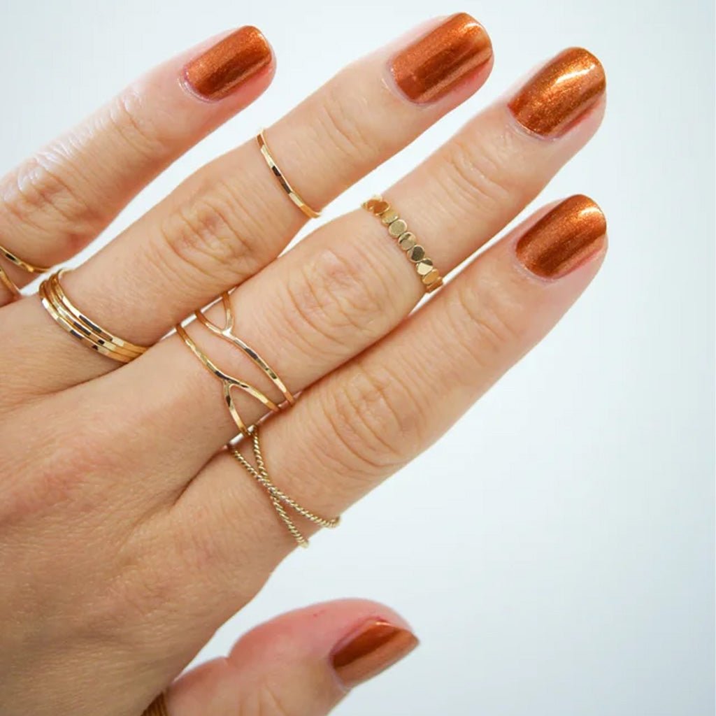 Hand wearing shimmer brown sugar nail polish