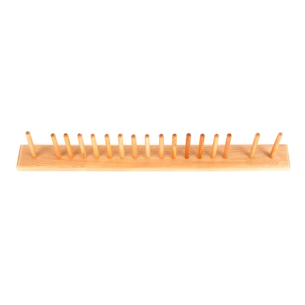 A wooden brush rack with pegs on white background